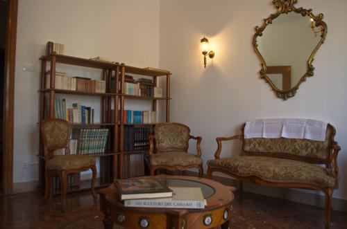 a living room with two chairs and a table and a mirror at Olivarooms in Palermo