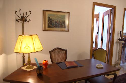 a dining room with a table and a lamp at Olivarooms in Palermo