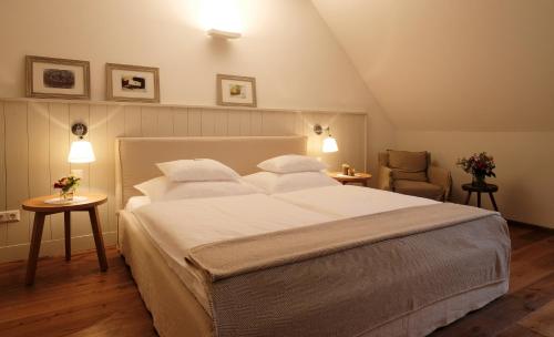 ein Schlafzimmer mit einem großen weißen Bett und einem Stuhl in der Unterkunft Auszeit in Apetlon