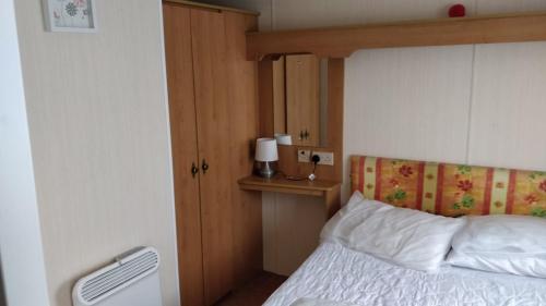 a bedroom with a bed with a wooden head board at Sealands Ingoldmells 6 Berth Panel heated Baysdale in Ingoldmells