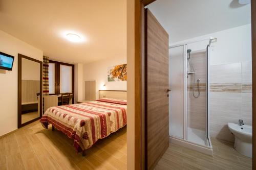 アオスタにあるMaison de Rosy Chambresのベッドルーム1室(ベッド1台付)、バスルーム(シャワー付)が備わります。