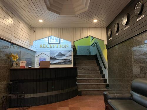 a room with a staircase with a sign that reads reception at JC Woodville Manor in Kodaikānāl