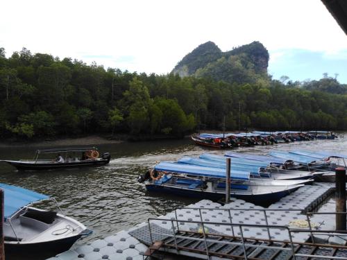 a group of boats parked at a dock on a river at Homestay Haji Hamid in Pantai Cenang