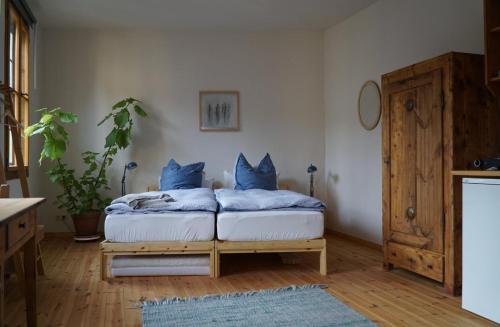 a bedroom with a bed with blue pillows on it at Pension zum Hirschstein in Greiz