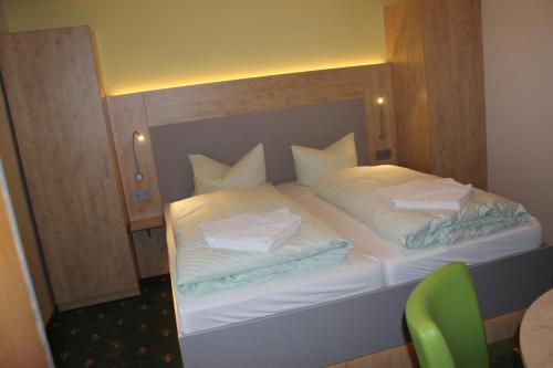 a bedroom with a bed with white sheets and pillows at Landhotel Gasthof Zwota in Klingenthal
