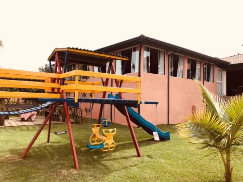 a playground in front of a house with a slide at Hotel Imigrantes in São Pedro