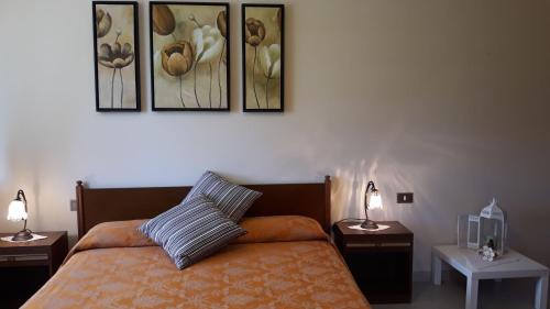 a bedroom with a bed with three pictures on the wall at Agriturismo Persichitti in Torricella Peligna