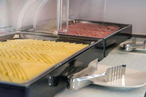 a grill with hot dogs and a plate of food at Anesis Hotel in Agia Pelagia Kythira