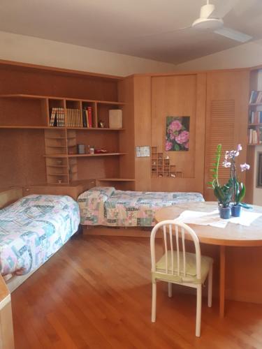 a bedroom with two beds and a table with a chair at B&B DUE ABETI in Florence
