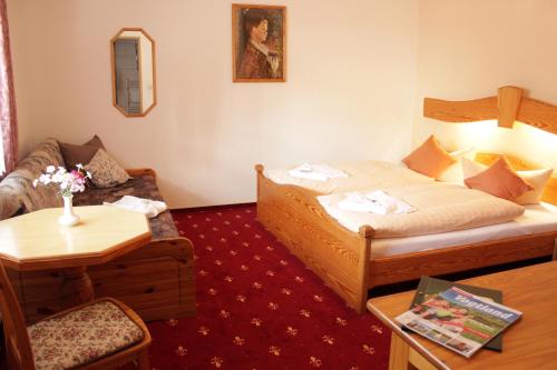 a small hotel room with a bed and a couch at Landhotel Gasthof Zwota in Klingenthal