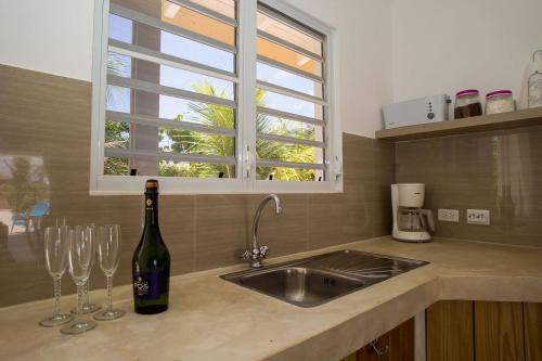 una botella de vino sentada en un mostrador con dos copas de vino en Appartement Barracuda, en Kralendijk