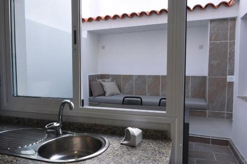 a bathroom with a sink and a mirror with a couch at Casa Serena in Puerto de la Cruz