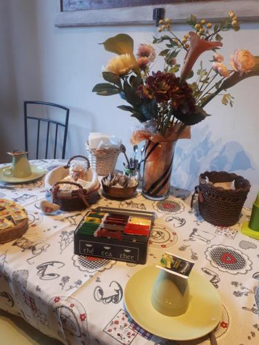 uma mesa com uma toalha de mesa com flores e um vaso em B&B DUE ABETI em Florença