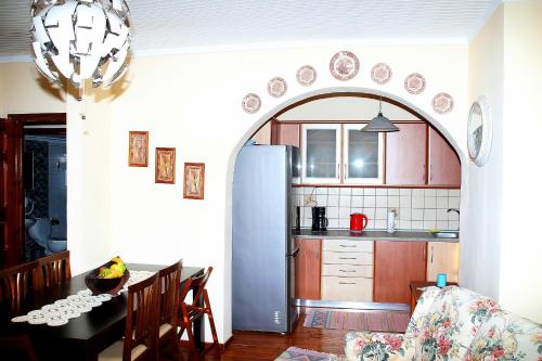 a kitchen with an archway over a table and a refrigerator at VILLA OLGA in Prinos