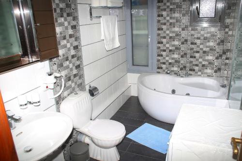 a bathroom with a toilet and a tub and a sink at VILLA OLGA in Prinos
