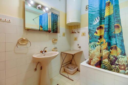 a bathroom with a sink and a shower curtain at Apartments Helena, Mali Lošinj in Mali Lošinj