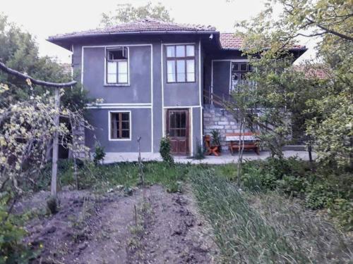 una casa púrpura con un banco delante de ella en BeeFree, en Gorsko Slivovo