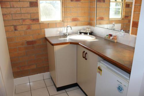 a bathroom with a sink and a mirror at Copper Country Motor Inn in Nanango