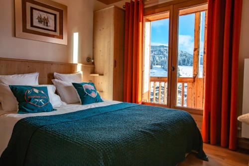 a bedroom with a bed and a large window at Le Grand Canyon in Les Gets