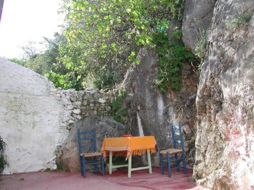 una mesa y sillas sentadas junto a una pared en Las Parras en Rute