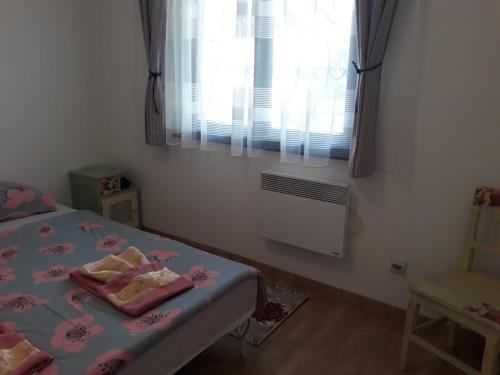 a small bedroom with a bed and a window at Apartman Dijelovi in Bijeljina