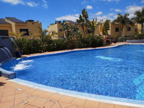 a large swimming pool with blue water in a yard at Bahía Meloneras in Meloneras