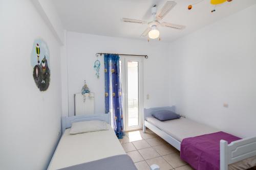 - 2 lits dans une chambre avec fenêtre dans l'établissement Villa Leiland, à Panormos