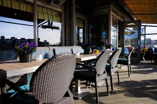 - une rangée de tables et de chaises sur la terrasse dans l'établissement Hotel Meyer, à Bergen aan Zee
