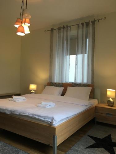 a bedroom with a bed with white sheets and a window at WALDSHUT SUITE IN ZENTRUM in Waldshut-Tiengen