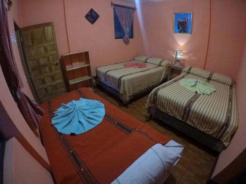 a room with two beds in a room at Hotel Encuentro del Viajero in Panajachel