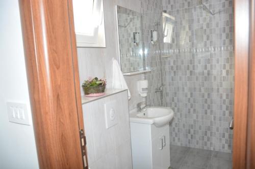 a bathroom with a sink and a toilet and a shower at Apartmani Gaga in Tivat