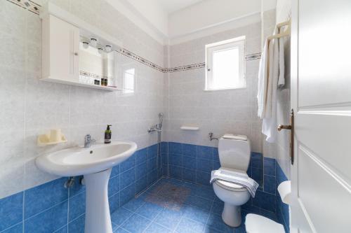 a blue and white bathroom with a toilet and a sink at Kassiani Studios in Plakias