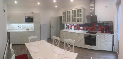una cucina con armadi bianchi, tavolo e sedie di zentral gelegene top ausgestattete Wohnung a Wurzen