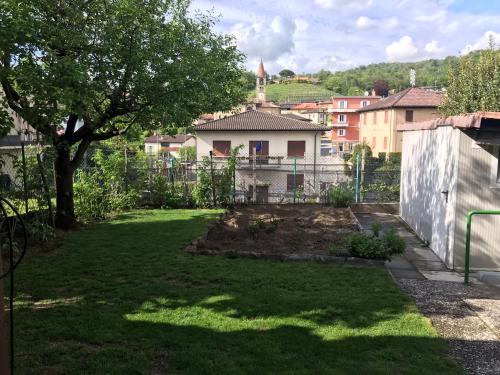a yard with a fence and a tree at Comano Lugano Ticino - B&B Walterina in Comano