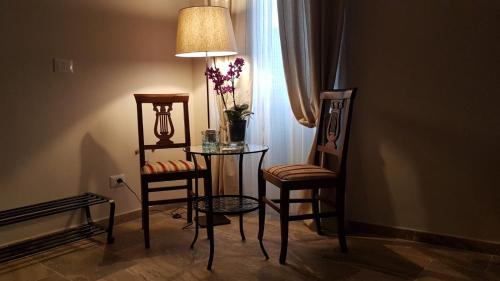 une chambre avec une table, deux chaises et une lampe dans l'établissement La Salita B&B, à Viterbe