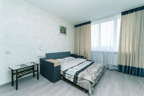 1 dormitorio con cama, mesa y ventana en 1к квартира 20 мин от центра, en Kiev