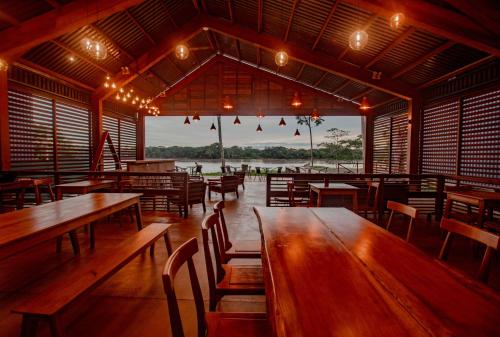 an empty restaurant with wooden tables and chairs at Enai in Puerto Maldonado