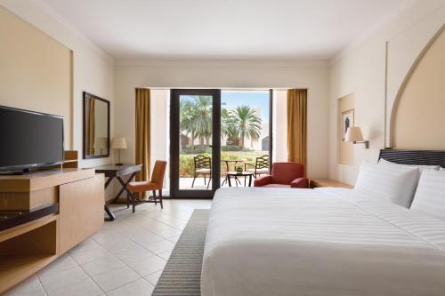 a hotel room with a large bed and a television at Shangri-La Barr Al Jissah, Muscat in Muscat