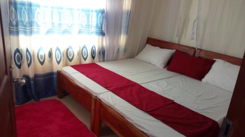 a small bed in a room with a window at Sun Set Paradise Baringo 11 in Mombasa