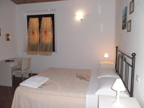 een slaapkamer met een bed, een bureau en een raam bij Poggio Petrella in Manciano