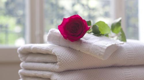 a rose on top of towels with a flower on top at Romantic Apartment El Corte Inglês in Lisbon