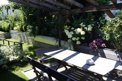 einen Tisch und Stühle in einem Garten mit Blumen in der Unterkunft Villa Karin in Adnet