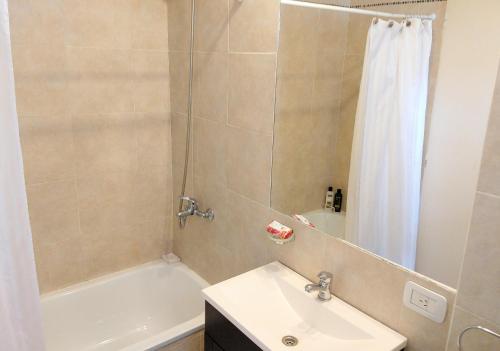 Un baño con bañera, lavabo y ducha. en Abasto Gardel Tango, en Buenos Aires