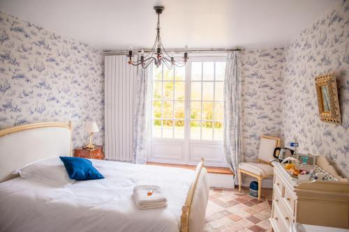 una camera con un grande letto e una finestra di Chambre chez l'habitant a Orsay