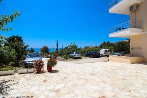 a parking lot of a building with cars parked at Hotel Afrodite in Dhërmi