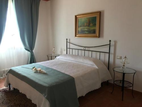 a bedroom with a bed with a green blanket and a window at La Mennula in Ballata