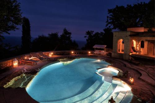 a swimming pool at night with lights around it at Chateau Cascara in Mouresi