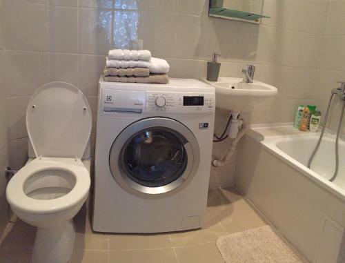 a bathroom with a washer and a toilet and a sink at Charming apartment in Odesa