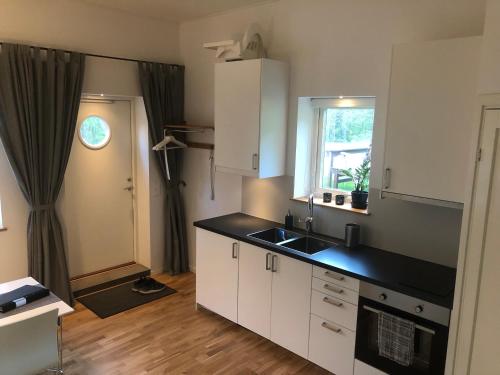 a kitchen with white cabinets and a black counter top at Duvberget in Kolmården