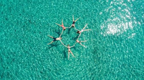a group of people swimming in the water at Alonissos beach villa 5 steps away from the sea in Kalamakia